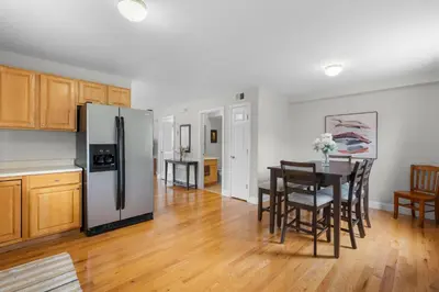 a kitchen and dining room with a refrigerator and a table at Near YALE - Beautiful Waterfront Townhouse in New Haven in New Haven