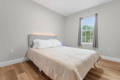 a white bedroom with a large bed with a window at Near YALE - Beautiful Waterfront Townhouse in New Haven in New Haven