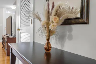 a vase with flowers sitting on a table at Near YALE - Beautiful Waterfront Townhouse in New Haven in New Haven