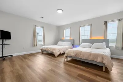 a white room with two beds and a flat screen tv at Near YALE - Beautiful Waterfront Townhouse in New Haven in New Haven