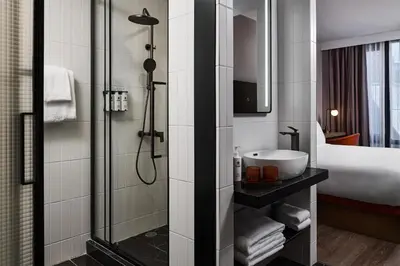 a bathroom with a sink and a shower at The George Manhattan, Tapestry Collection By Hilton in New York