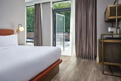a hotel room with a bed and a balcony at The George Manhattan, Tapestry Collection By Hilton in New York