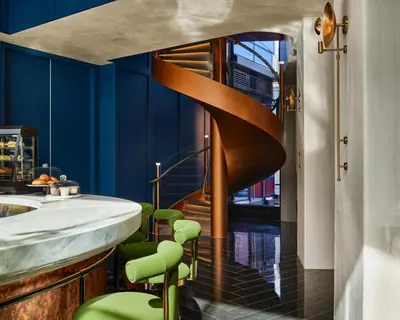 a spiral staircase in a bathroom with green stools at The George Manhattan, Tapestry Collection By Hilton in New York