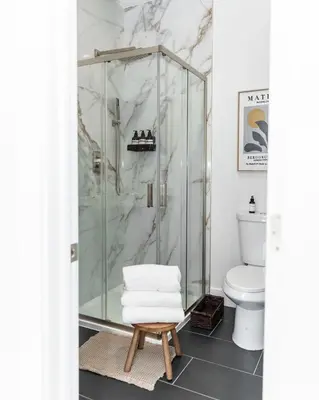 a bathroom with a shower with a toilet and a stool at Quiet close to NYC BBQ Deck in Jersey City