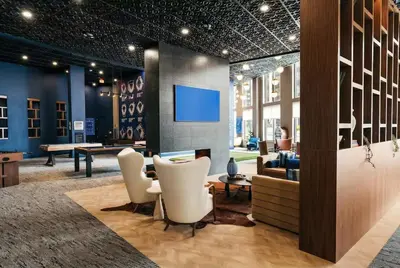 a lobby with chairs and a table and a tv at Luxury Apartments by Hyatus White Plains in White Plains