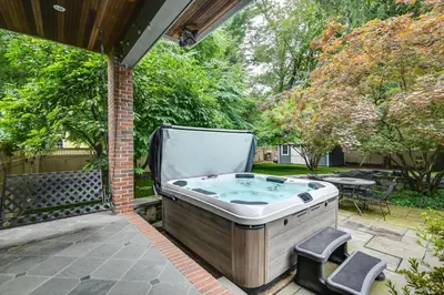 a hot tub on the patio of a house at Hot Tub, Gym, Game Room! Luxe Estate in Longmeadow in Longmeadow