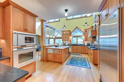 a large kitchen with wooden cabinets and stainless steel appliances at Hot Tub, Gym, Game Room! Luxe Estate in Longmeadow in Longmeadow
