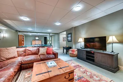 a living room with a couch and a flat screen tv at Hot Tub, Gym, Game Room! Luxe Estate in Longmeadow in Longmeadow