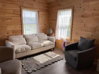 a living room with a white couch and two chairs at Countryside Views in Norwich