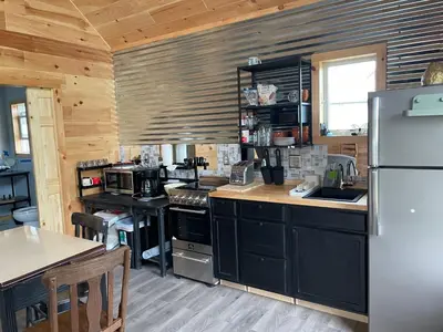 a kitchen with black cabinets and a stainless steel refrigerator at Countryside Views in Norwich
