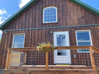 a wooden barn with a porch and a window at Countryside Views in Norwich