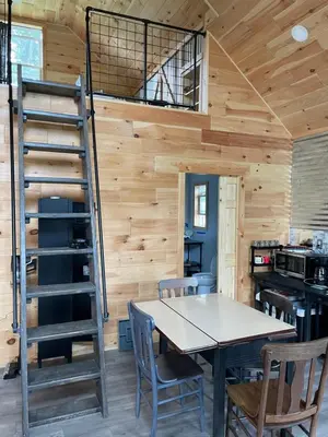 a kitchen and dining room with a ladder in a tiny house at Countryside Views in Norwich