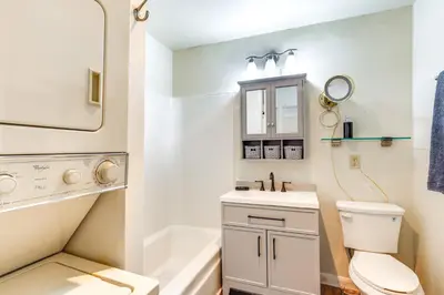 a bathroom with a toilet and a sink and a mirror at 1 Mi to Dtwn Saratoga Springs Cozy Duplex Apt! in Saratoga Springs