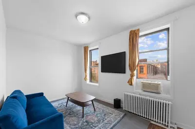 a living room with a blue couch and a window at NY-11-7 Cozy 1BR 1BATH In East Village in New York