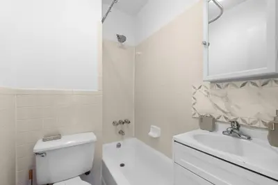 a white bathroom with a toilet and a sink at NY-11-7 Cozy 1BR 1BATH In East Village in New York