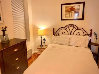 a bedroom with a bed and a dresser with a lamp at PRIME LOCATION 2 BEDROOMS APT UPPER EAST SIDe in New York