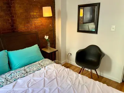 a bedroom with a bed and a chair and a mirror at PRIME LOCATION 2 BEDROOMS APT UPPER EAST SIDe in New York