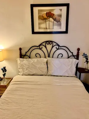 a bed with a white bedspread and a picture on the wall at PRIME LOCATION 2 BEDROOMS APT UPPER EAST SIDe in New York