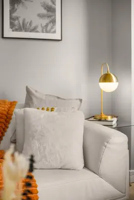 a white couch with a pillow and a lamp at Chic NYC Retreat Beside Broadway & Iconic Sights in New York