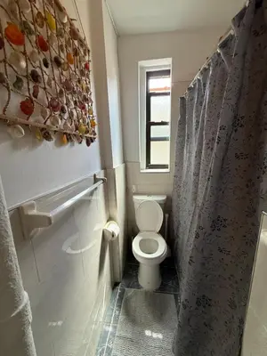 a small bathroom with a toilet and a window at Bronx City Stay Private Room Near Manhattan in Kings Bridge Heights