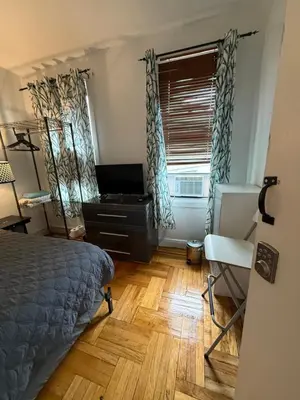 a bedroom with a bed and a desk and a window at Bronx City Stay Private Room Near Manhattan in Kings Bridge Heights