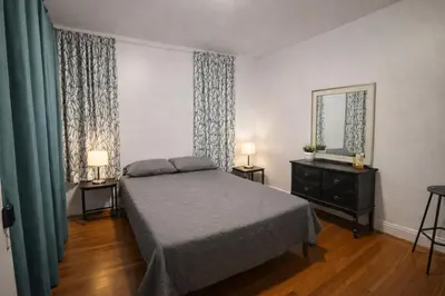 a bedroom with a bed and a dresser and a mirror at Bronx City Stay Private Room Near Manhattan in Kings Bridge Heights
