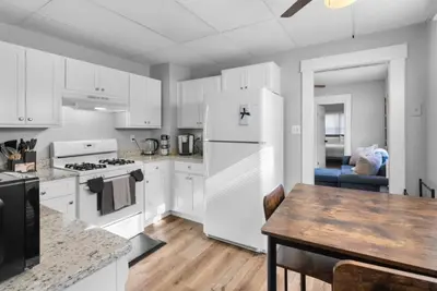a kitchen with white appliances and a wooden table at Cozy Bedroom next to SCSU in New Haven