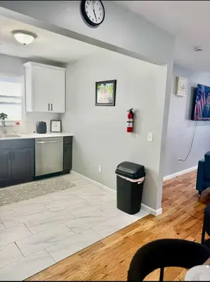 a kitchen with a counter and a clock on the wall at Cozy Rooms in a Modern and Beautiful Apartment in Irvington