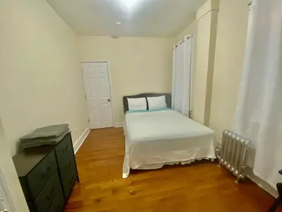 a small bedroom with a bed and a dresser at Tropical Oasis - Room 1 in Irvington