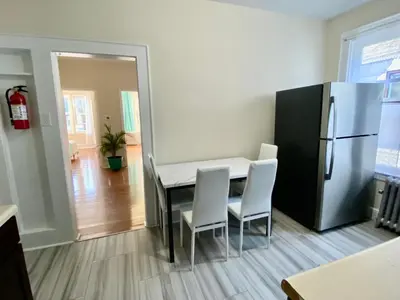 a kitchen with a dining room table and a refrigerator at Tropical Oasis - Room 1 in Irvington