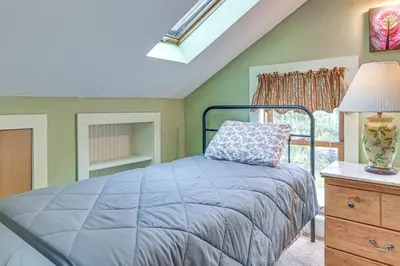 a bedroom with a bed and a lamp and a window at Quaint and Charming Cherry Valley Escape! in Cherry Valley