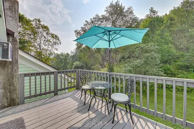 a table and two chairs on a deck with an umbrella at Quaint and Charming Cherry Valley Escape! in Cherry Valley