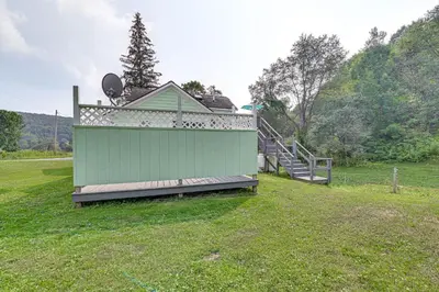 a green building in a field with a staircase at Quaint and Charming Cherry Valley Escape! in Cherry Valley