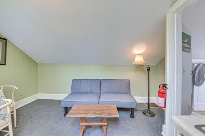 a living room with a blue couch and a table at Quaint and Charming Cherry Valley Escape! in Cherry Valley