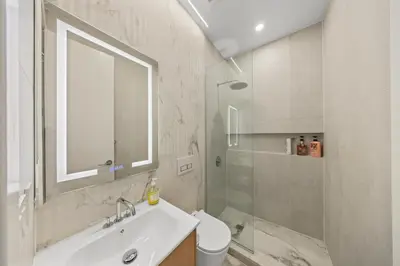 a white bathroom with a sink and a shower at Double Room at a shared Apartment near Times Square in New York