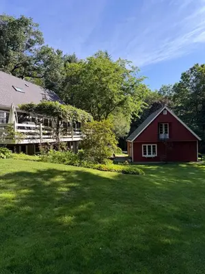 a red barn and a house with a yard at Beautiful House in the Woods, Huge Yard, Hot Tub in Great Barrington