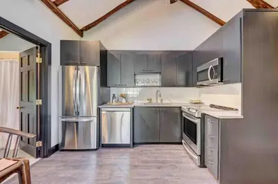 a kitchen with stainless steel appliances and gray cabinets at Longpond Farm House and Loft in Salisbury