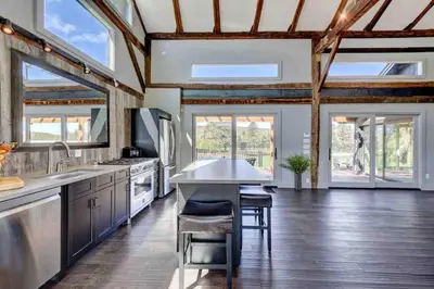 a kitchen with wooden ceilings and a wooden floor at Longpond Farm House and Loft in Salisbury