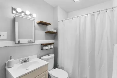a bathroom with a white shower curtain and a toilet at Quiet & Cozy Room by SCSU in New Haven