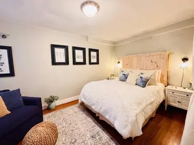 a bedroom with a large bed and a blue couch at Neighborhood Apt-walk to Train-McLean Ave, 30mins to NYC in Yonkers