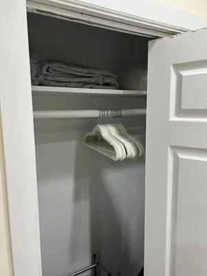 a closet with white shelves and towels in it at Hells Kitchen Hideaway in New York