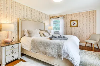 a bedroom with a large bed and a chair at 1 Mi to Vineyard Serene Berkshires Country Escape in Richmond