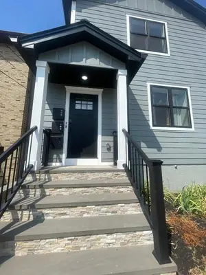 a house with a front porch with a black door at NYC Edge Triplex Full House | Parking & Near Shops in North Bergen