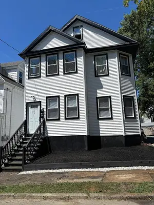 a white house with a staircase in front of it at 3 bedroom 1 bathroom apartment , free private parking in Schenectady