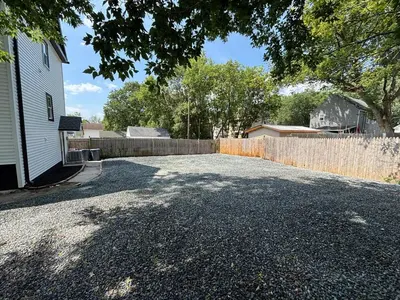 a driveway in front of a fence next to a house at 3 bedroom 1 bathroom apartment , free private parking in Schenectady