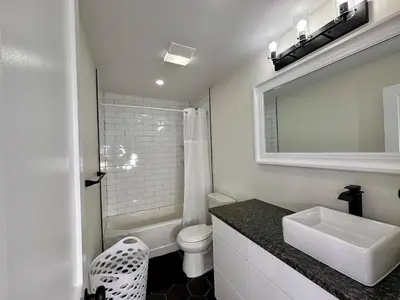 a white bathroom with a sink and a toilet at 3 bedroom 1 bathroom apartment , free private parking in Schenectady