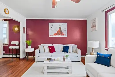 a living room with a white couch and a red wall at NEW 