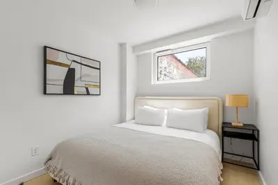 a white bedroom with a bed and two windows at Blueground Williamsburg view nr East River NYC-1958 in Brooklyn