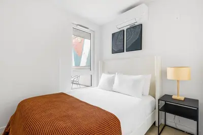 a white bedroom with a bed and a window at Blueground Williamsburg view nr East River NYC-1958 in Brooklyn