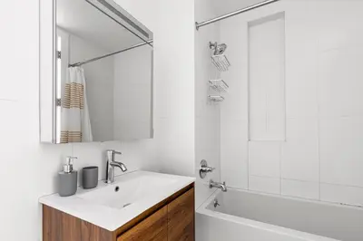 a white bathroom with a sink and a tub at Blueground Williamsburg view nr East River NYC-1958 in Brooklyn